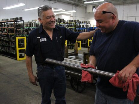 Marty patting co-worker on his back, laughing and smiling