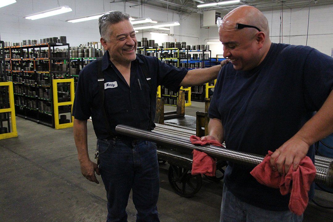 Marty patting co-worker on his back, laughing and smiling