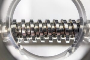 Close-Up inspection of a rolled thread bolt with magnifying glass to ensure high quality production